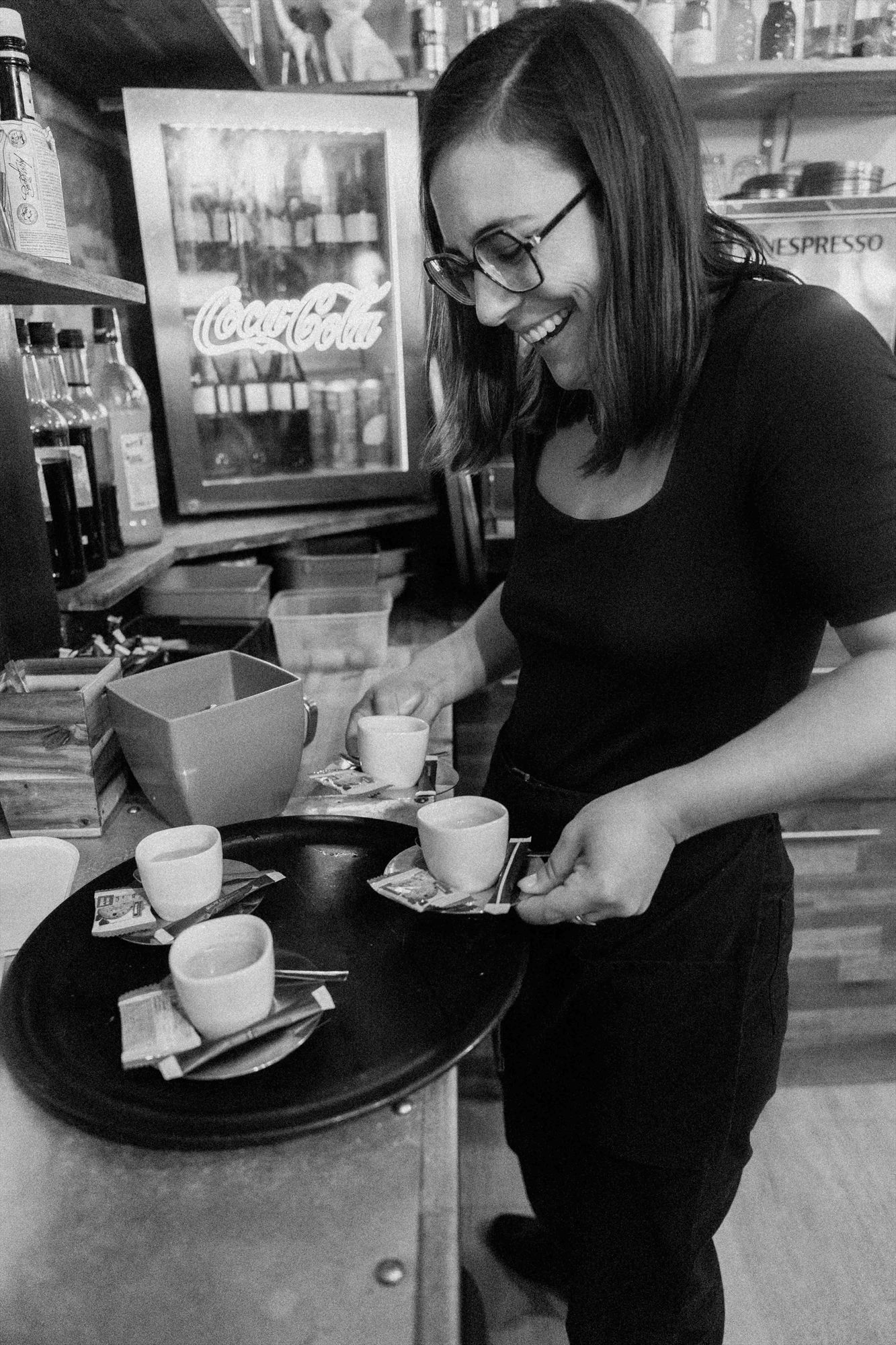 Une serveuse sourit en préparant les cafés au bar de la Crêperie du Port