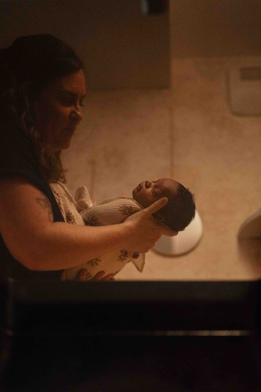 Anne-Laure porte le nouveau-né dans ses mains avant le bain