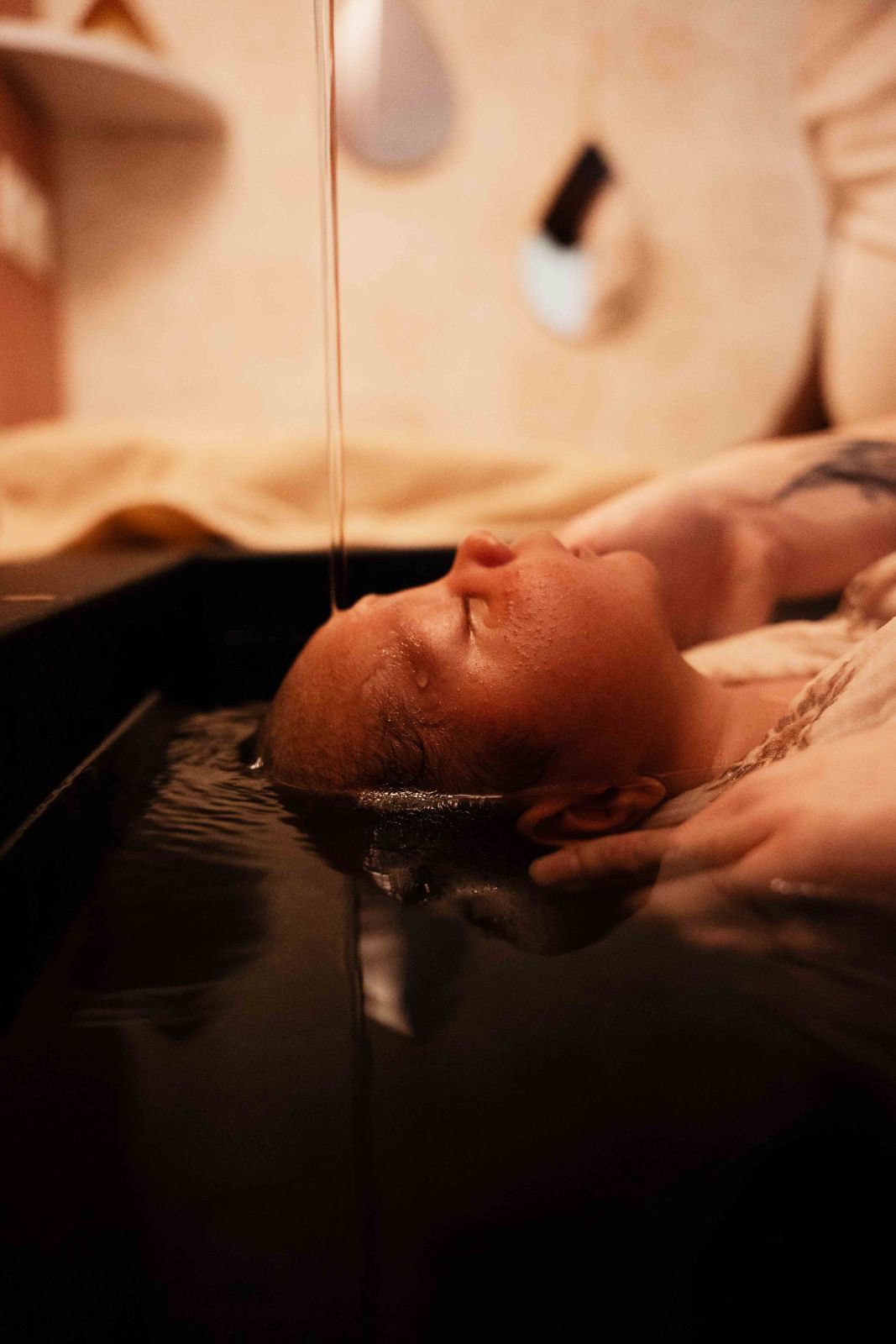 Bébé détendu dans l'eau pendant un bain bébé chez Graines de Lys