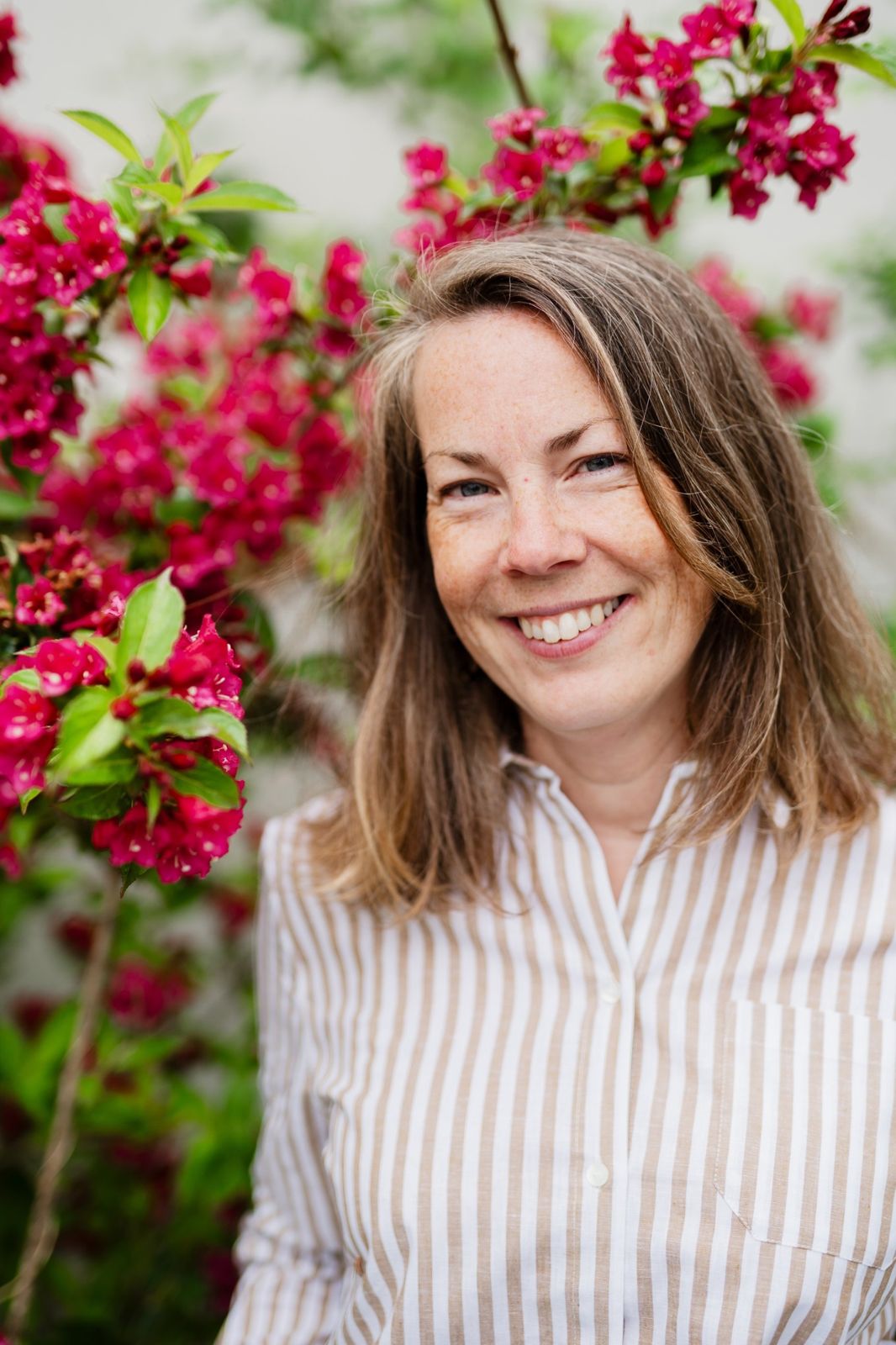 Audrey Marcoux, coach et sophrologue Plume et Harmonie, souriante devant des fleurs