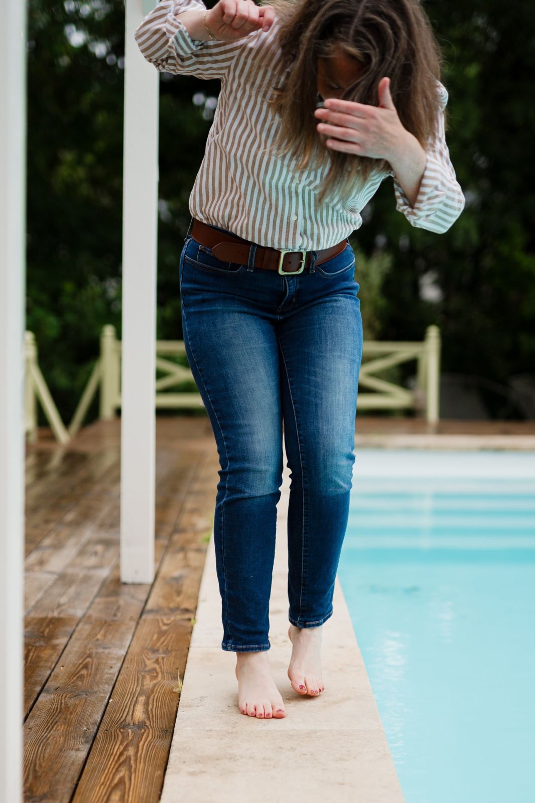 Audrey marche pieds nus sur le bord de la piscine
